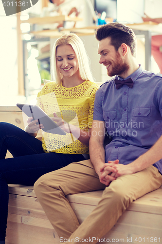 Image of happy creative team with tablet pc in office