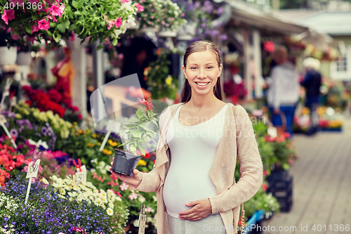 Image of pregnant woman choosing flowers at street market