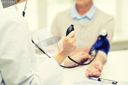 Image of doctor with tonometer and senior woman at hospital