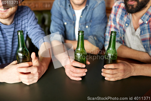 Image of happy male friends drinking beer at bar or pub