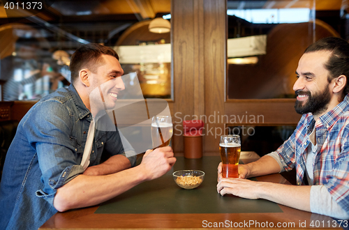 Image of happy male friends drinking beer at bar or pub