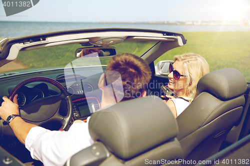 Image of happy man and woman driving in cabriolet car