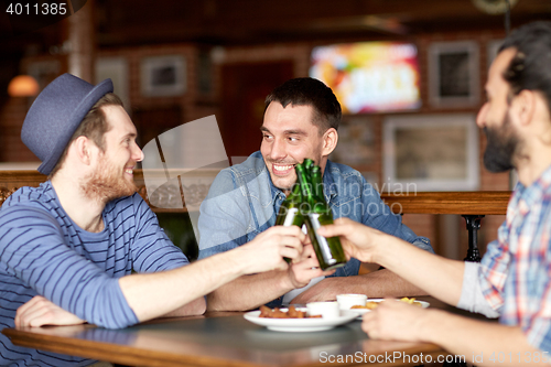 Image of happy male friends drinking beer at bar or pub