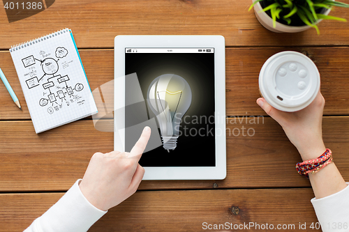 Image of close up of woman with tablet pc on wooden table