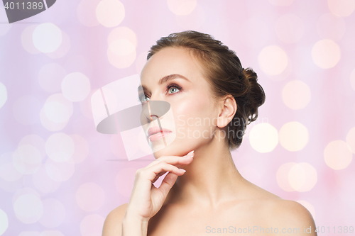 Image of beautiful young woman touching her face