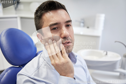 Image of man having toothache and sitting on dental chair