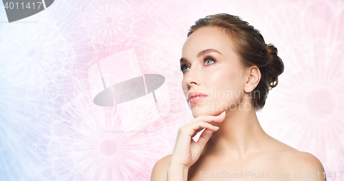 Image of beautiful young woman touching her face