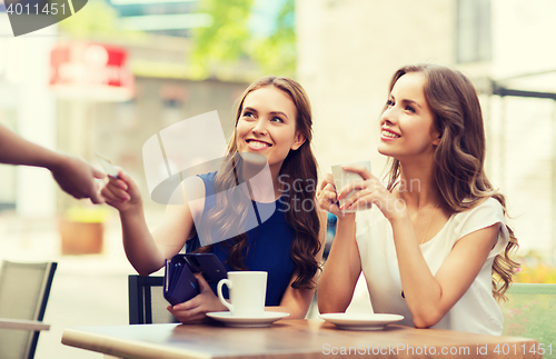 Image of women with credit card paying for coffee at cafe