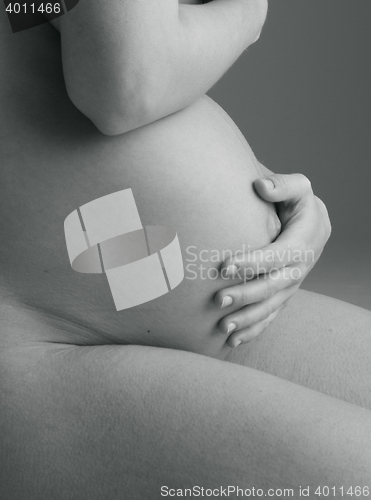 Image of Pregnant Woman holding her hands on beautiful belly