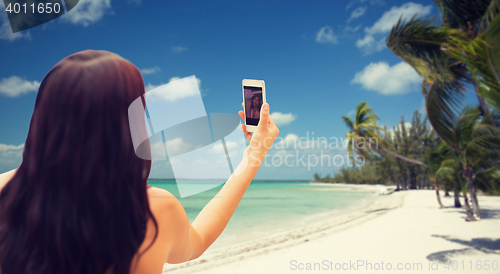 Image of young woman taking selfie with smartphone