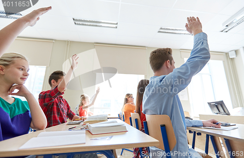 Image of group of students with raised hands at high school