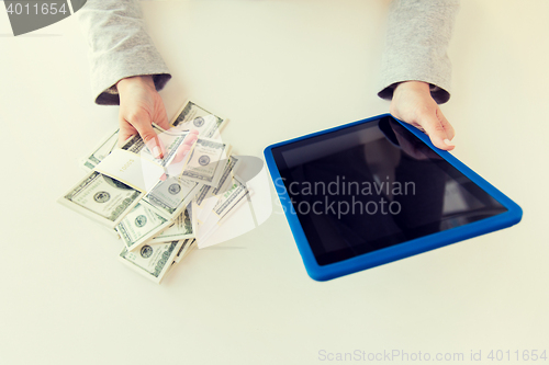 Image of close up of woman hands with tablet pc and money