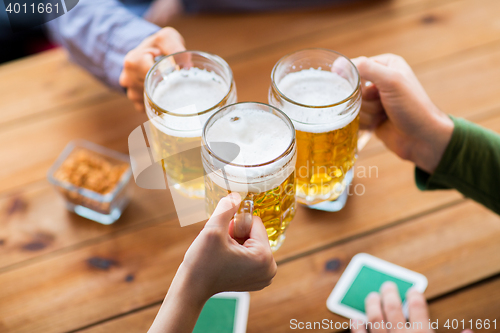 Image of close up of hands with beer mugs at bar or pub