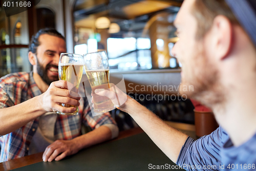 Image of happy male friends drinking beer at bar or pub