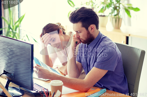 Image of business team with computer and files in office