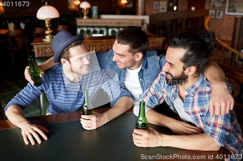 Image of happy male friends drinking beer at bar or pub