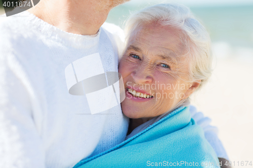 Image of happy senior couple hugging on summer beach