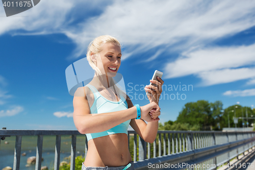 Image of happy woman with heart rate watch and smartphone