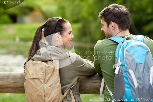 Image of smiling couple with backpacks in nature