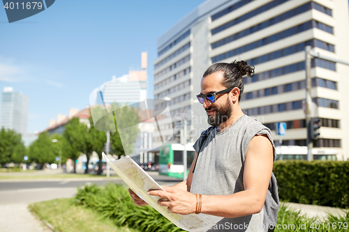 Image of man traveling with backpack and map in city