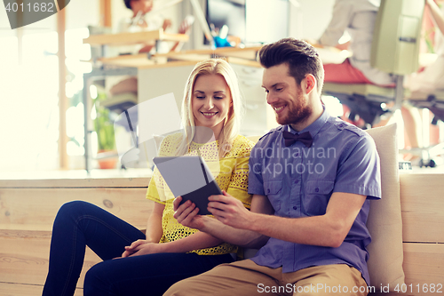Image of happy creative team with tablet pc in office