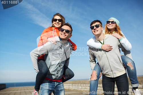 Image of happy teenage friends in shades having fun outdoors