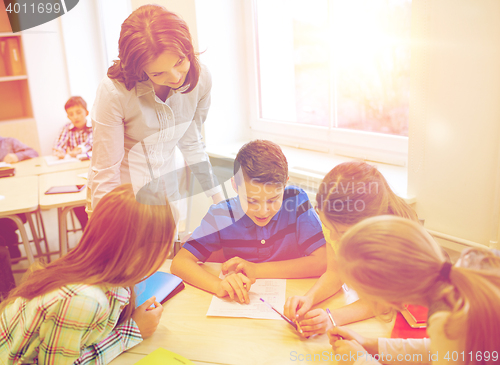 Image of group of school kids writing test in classroom