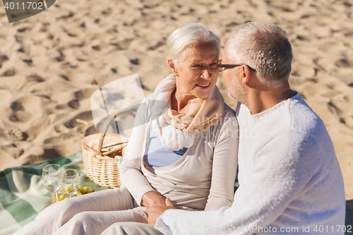 Image of happy senior couple talking on summer beach