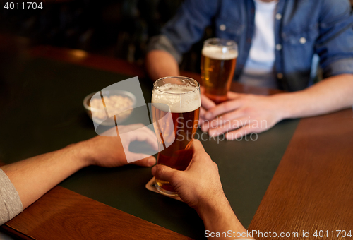 Image of close up of men drinking beer at bar or pub