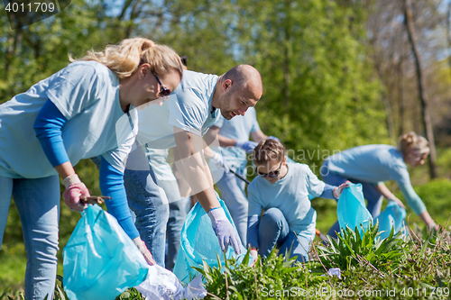 Image of volunteers with garbage bags cleaning park area