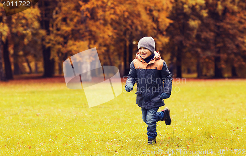 Image of happy little boy running on autumn park field