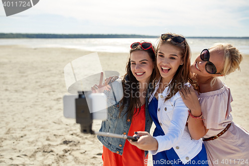 Image of group of smiling women taking selfie on beach