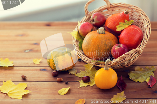 Image of close up of pumpkins in basket on wooden table