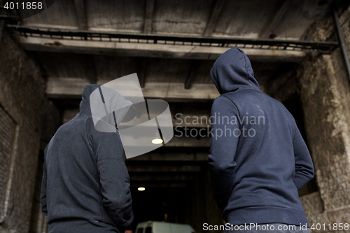 Image of addict men or criminals in hoodies on street