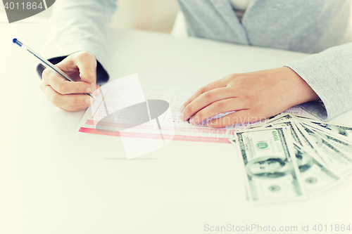 Image of close up of hands with lottery ticket and money