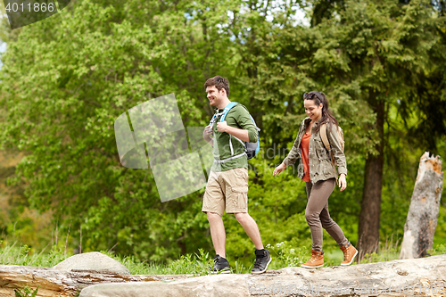 Image of happy couple with backpacks hiking outdoors