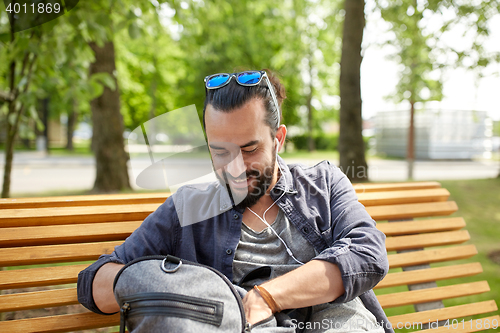 Image of man with backpack and earphones in city