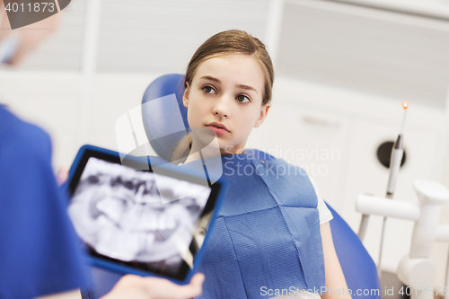 Image of dentist with x-ray on tablet pc and girl patient