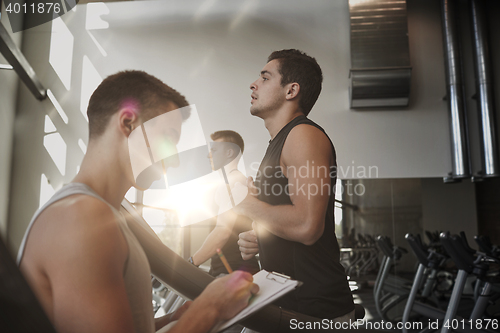 Image of men exercising on treadmill in gym