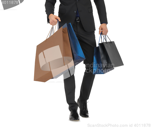 Image of close up of man in suit with shopping bags