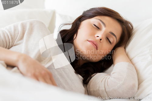 Image of young woman sleeping in bed at home