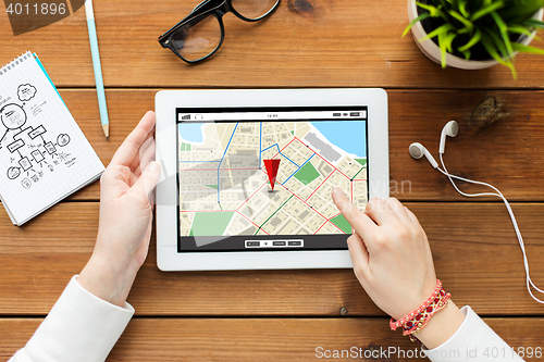 Image of close up of woman with tablet pc on wooden table