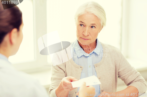 Image of doctor giving prescription to senior woman