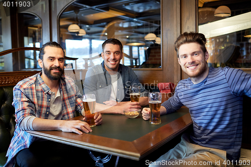 Image of happy male friends drinking beer at bar or pub