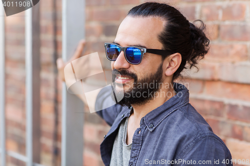 Image of happy smiling man with beard on city street