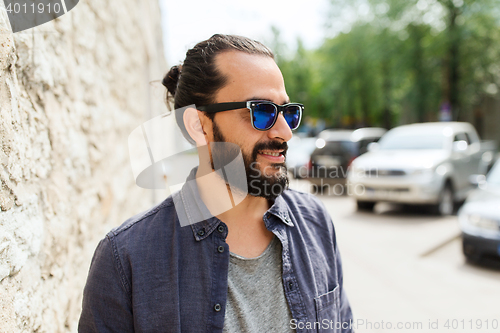 Image of happy smiling man with beard on city street