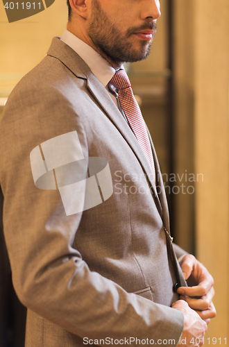 Image of close up of man trying suit at clothing store