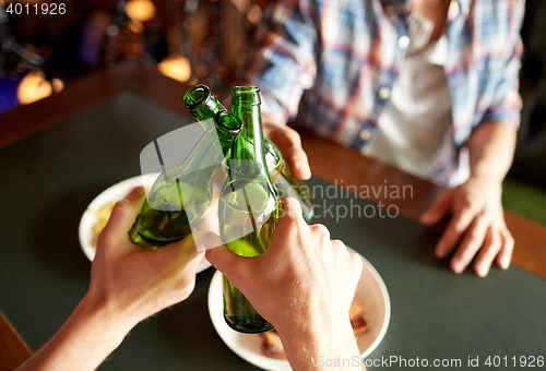 Image of close up of friends drinking beer at bar or pub