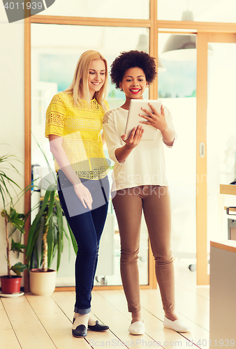 Image of happy creative team with tablet pc in office