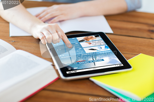 Image of close up of student with tablet pc and notebook